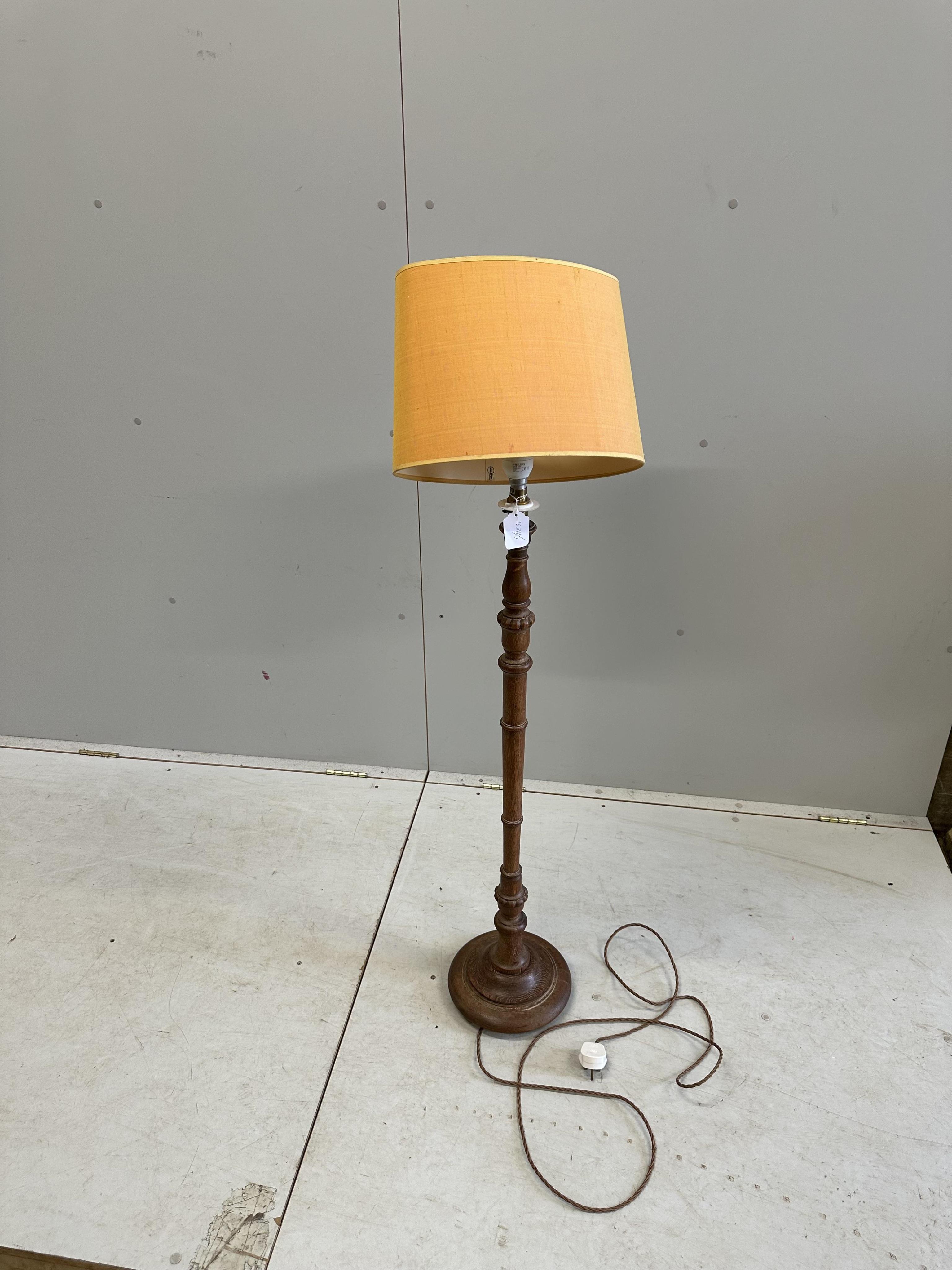 A 1930's turned oak standard lamp, height 97cm plus shade. Condition - good